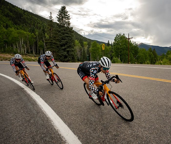 Drei Rennradfahrer beim Abwärtsfahren auf der Straße 