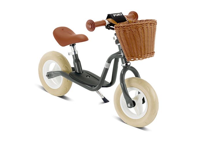 Ein Laufrad für Kinder mit geflochtenem Korb am Lenkrad.